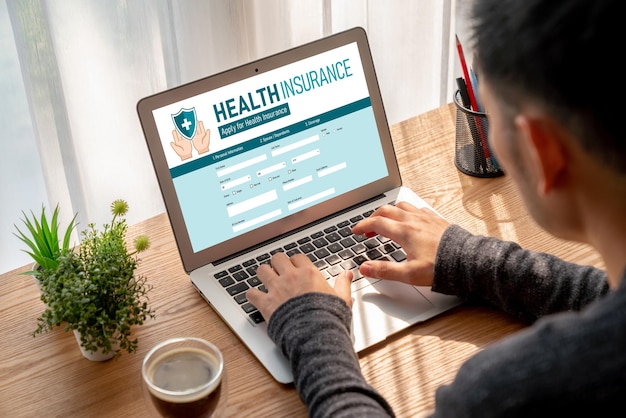 A person using a laptop with a health insurance comparison website displayed on the screen. Different plans and their costs are clearly visible.
