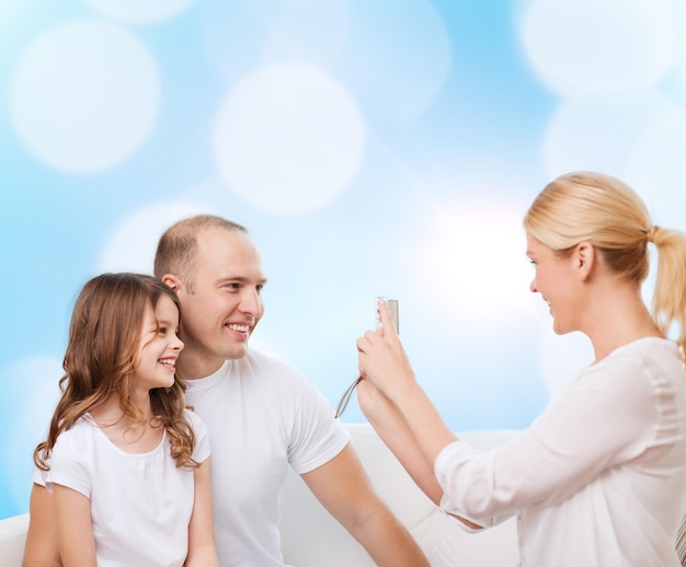 A family smiling and holding hands with a health insurance card visible in one of their hands, suggesting peace of mind and affordable healthcare.
