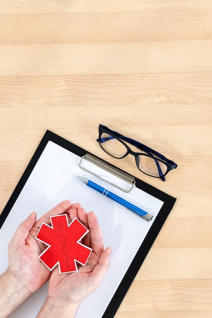 A close-up shot of a hand filling out a health insurance application form, with a pen hovering over a section about income and family size. The background is softly blurred, focusing on the process of applying for healthcare tax credits.
