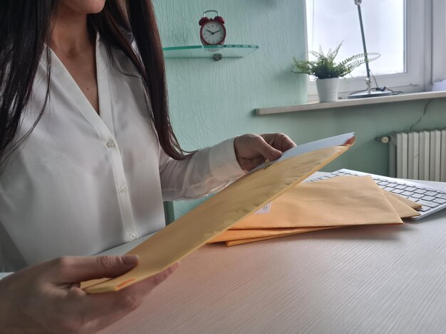 A close-up shot of a person organizing documents related to income, health insurance, and personal identification on a well-lit desk.