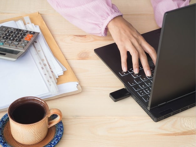 A close-up of a hand pointing to a subsidy calculator on a laptop screen. The background is a cozy home office setup.
