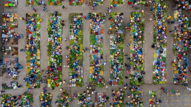 An aerial view of a bustling healthcare marketplace or fair, with people interacting at booths and engaging in conversations about health insurance options.