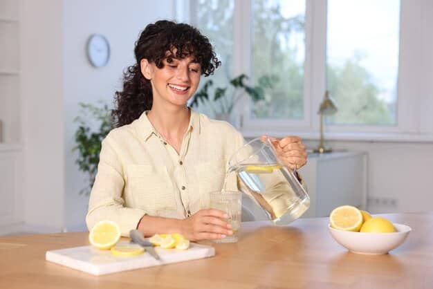 A person pouring a glass of water with lemon slices in a sunlit kitchen, emphasizing healthy hydration.