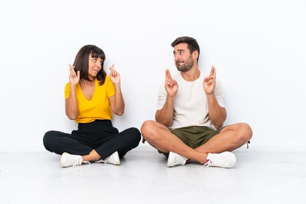 Two people sitting opposite each other. One person is gesturing slightly while speaking, and the other is leaning forward, maintaining direct eye contact with a gentle, receptive expression, showing deep engagement in their conversation.