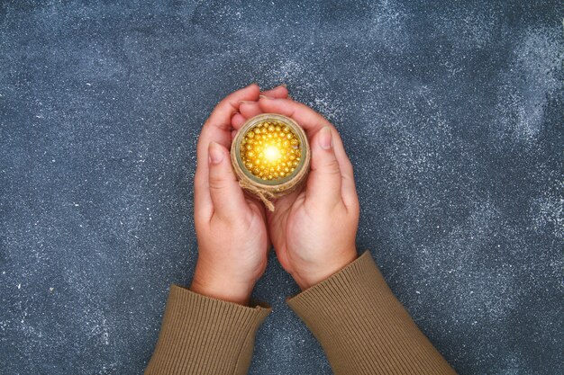 A person's hands gently cupped, holding a small glowing orb, symbolizing inner peace and gentle care.