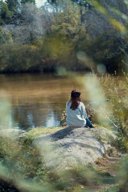 A calm person meditating or reflecting in a serene natural setting, embodying inner peace and mindful connection.