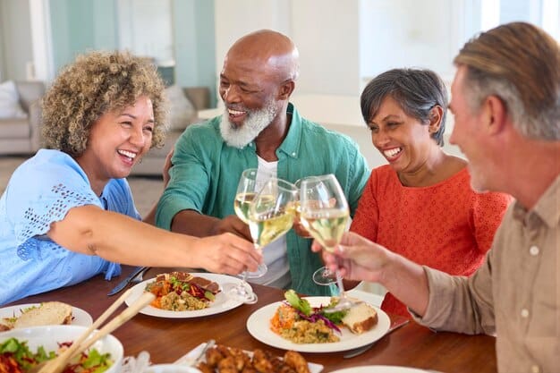 A group of diverse people smiling and laughing together, sharing a meal, symbolizing community, connection, and shared appreciation.