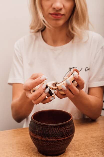 A person gently holding a small, cherished ceramic cup, contemplating its meaning before deciding whether to keep it. The background is slightly blurred, focusing on the thoughtful interaction with the object.