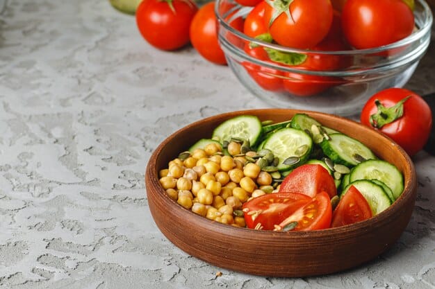 A close-up shot of a colorful, fresh salad bowl filled with mixed greens, cherry tomatoes, cucumber slices, bell peppers, and some chickpeas, illustrating a healthy and vibrant meal.