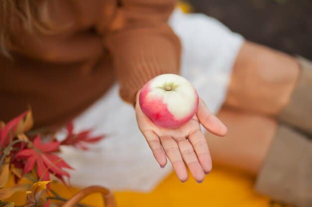 A close-up of a person's hand holding a single, vibrant green apple, symbolizing simple, natural healthy eating. The background is slightly blurred to keep focus on the apple.