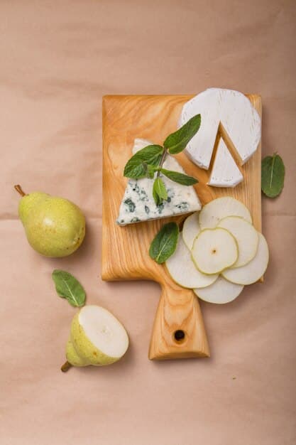A rustic wooden cutting board with a small, ripe pear sliced alongside a thin wedge of low-fat cheddar cheese.
