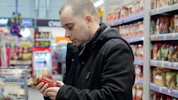 A person's hand holding a food package, specifically pointing to the 