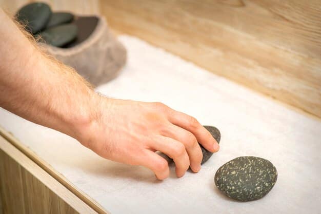 A person's hand holding a smooth, polished stone, with a focused expression, demonstrating a grounding technique through touch.