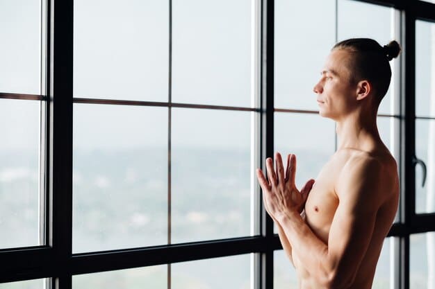 A person practicing yoga indoors, bathed in soft, natural light, reflecting serenity and focus. They are in a gentle pose, suggesting mindfulness and core strength.