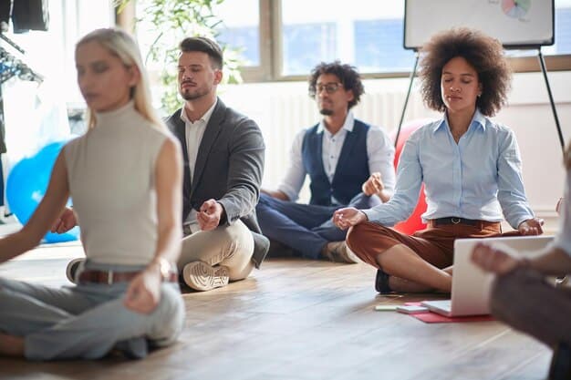 A diverse group of smiling employees participating in a workplace wellness session, featuring yoga mats and mindfulness exercises, indicating positive engagement.
