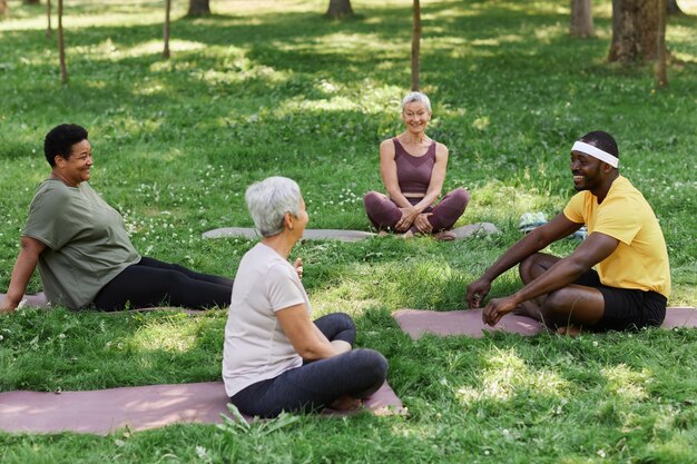 A diverse group of people engaged in various self-care activities: one meditating, another reading, someone exercising, and a person enjoying nature, all looking peaceful and content.