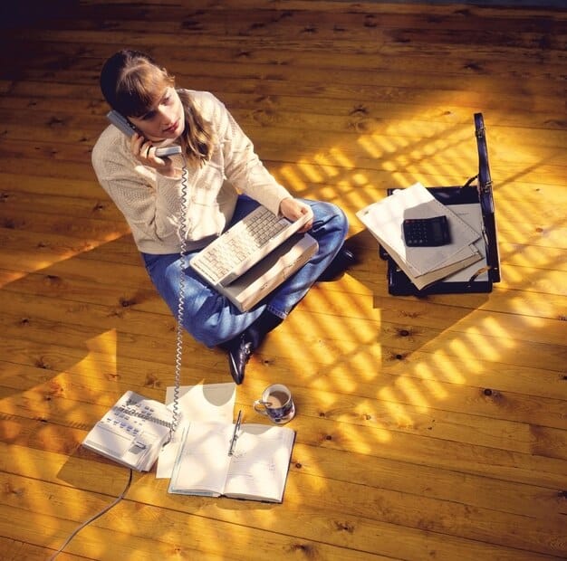 A person sitting at a desk, surrounded by books, a laptop, and notes, looking thoughtful but determined. Represents focused self-study and overcoming learning challenges.