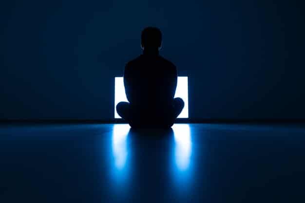 A person focused deeply on their laptop, surrounded by a subtle digital aura representing deep concentration, with blurred elements of an office or home setting in the background, illustrating the act of minimizing distractions for focused work.