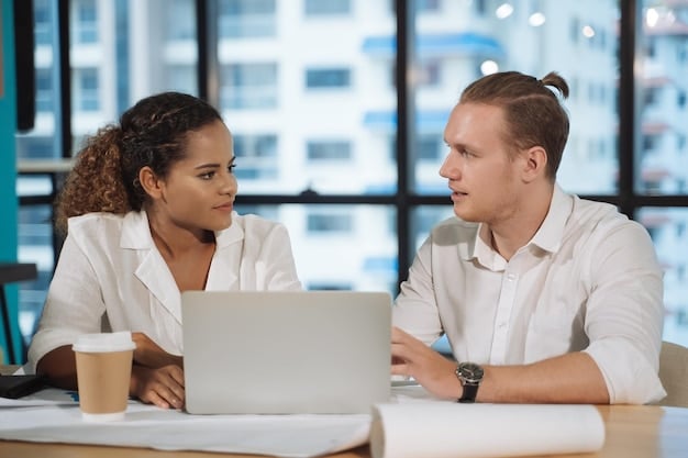 Two coworkers at a desk, one leaning in attentively with open body language and eye contact, while the other speaks with confidence and gestures, showing high awareness of Practical Solutions: A Step-by-Step Guide to Mindful Communication in the Workplace.