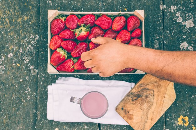 A close-up of a hand holding a package of organic strawberries with the USDA Organic seal clearly visible. The background is blurred, focusing attention on the certification mark.