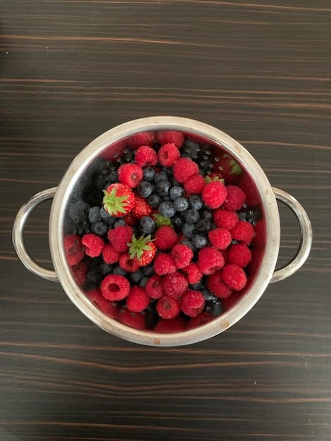 A detailed, overhead shot of a vibrant bowl filled with mixed berries (blueberries, raspberries, strawberries). The berries look fresh and juicy, and the composition highlights the natural colors and textures associated with antioxidants. The image is well-lit, emphasizing the health benefits and freshness of these antioxidant-rich foods and their role in The Power of Antioxidants: Foods to Protect Your Cells in 2025.