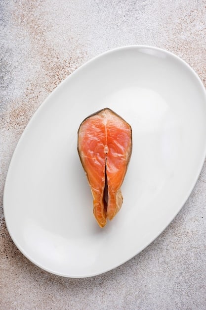 An eye-level close-up of a plate divided into sections. One section features salmon with visible omega-3 fat marbling, symbolizing healthy fats. Another section displays vibrant mixed berries (blueberries, raspberries, strawberries), representing nutrient-rich carbohydrates. The final section contains grilled tofu cubes, showcasing a vegetarian protein source. The background is blurred to keep the focus on the plate.