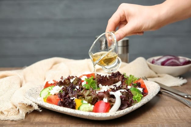 A close-up shot of a person drizzling olive oil over a colorful Mediterranean salad. The salad includes ingredients such as tomatoes, cucumbers, olives, feta cheese, and fresh herbs. The focus is on the olive oil being poured, highlighting its importance within the diet.