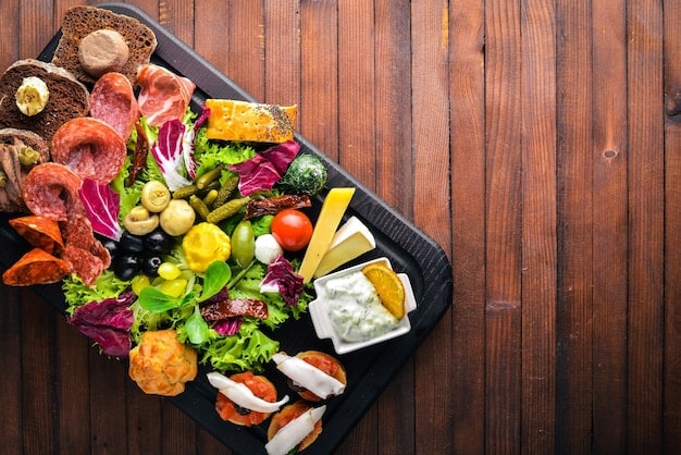 An overhead shot of a colorful snack platter featuring a variety of fruits, vegetables, cheese cubes, and whole-grain crackers. The arrangement is visually appealing and suggests a balanced mix of nutrients for healthy snacking, aligning with 