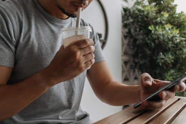 A person using a smartphone app to track their water intake, with a glass of water and a filled water bottle on a desk, representing the use of technology for monitoring hydration levels for optimal health.